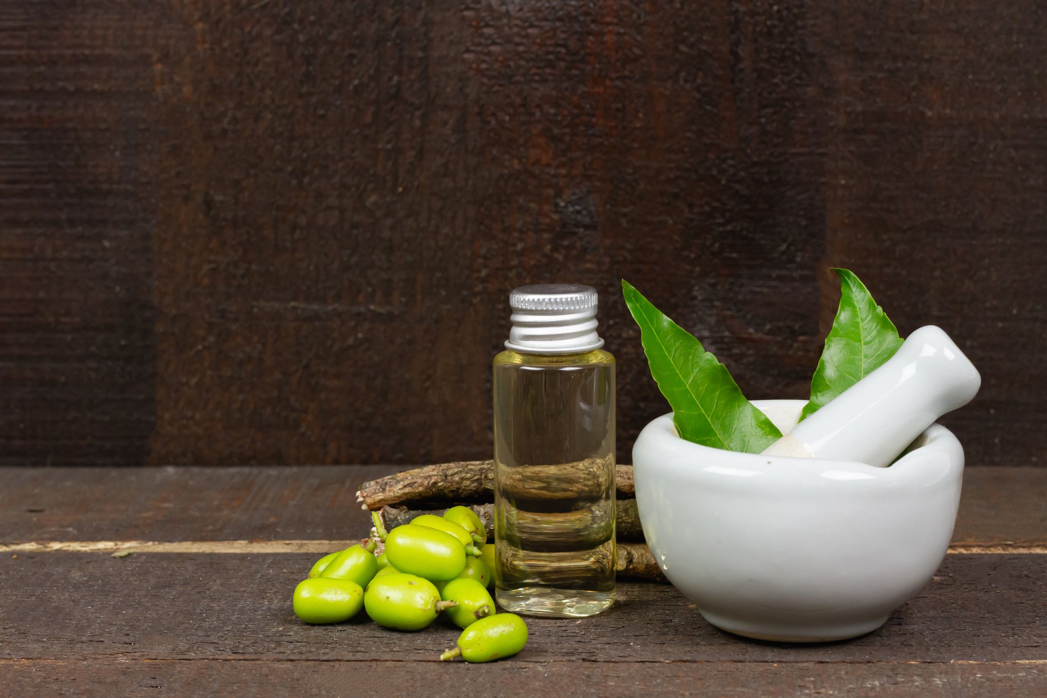 Neem oil in bottle and Neem leaf in mortar and pestle